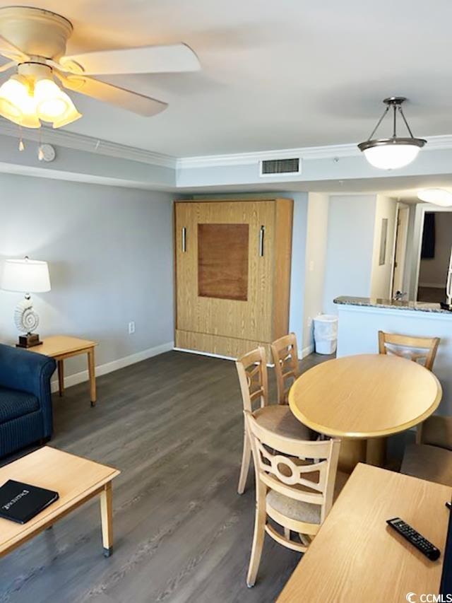 dining area featuring crown molding, dark hardwood / wood-style flooring, and ceiling fan