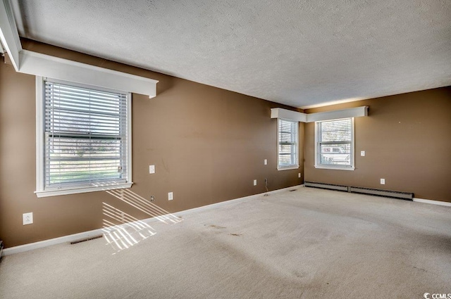 carpeted empty room featuring a textured ceiling and a baseboard radiator