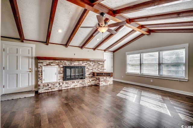 unfurnished living room featuring vaulted ceiling with beams, dark hardwood / wood-style flooring, a textured ceiling, and a brick fireplace