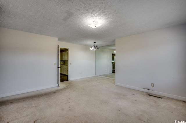 carpeted spare room with a textured ceiling