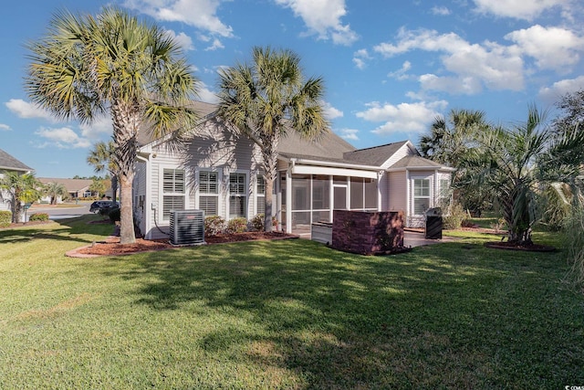 back of house with a lawn and a sunroom