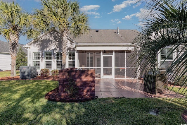 rear view of property with a sunroom, a yard, a patio, and central AC unit