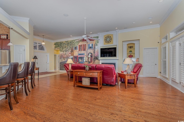 living room with ceiling fan, light hardwood / wood-style floors, and ornamental molding