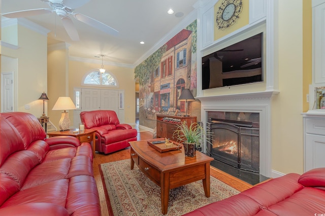 living room with hardwood / wood-style flooring, ceiling fan, and ornamental molding