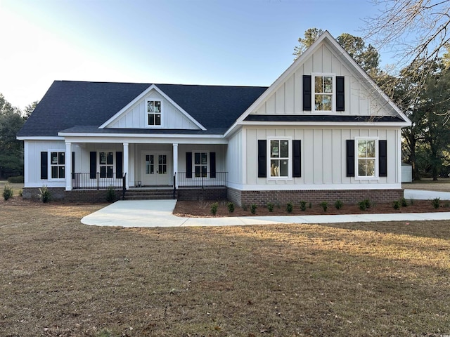 modern farmhouse featuring board and batten siding, french doors, and a front yard