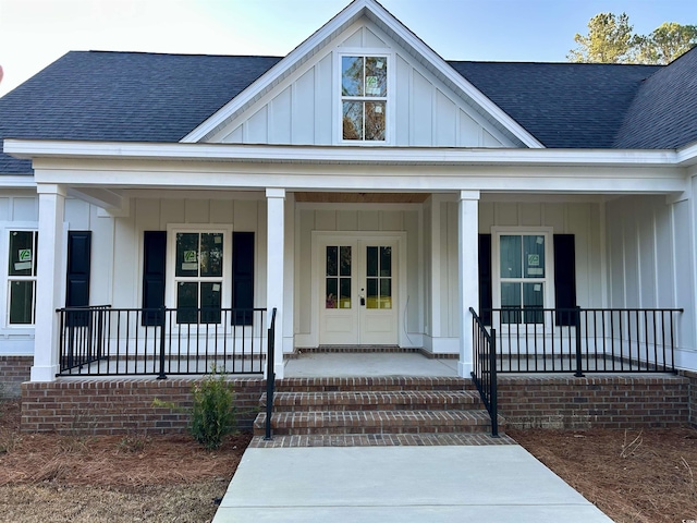 view of exterior entry featuring a shingled roof, board and batten siding, and a porch