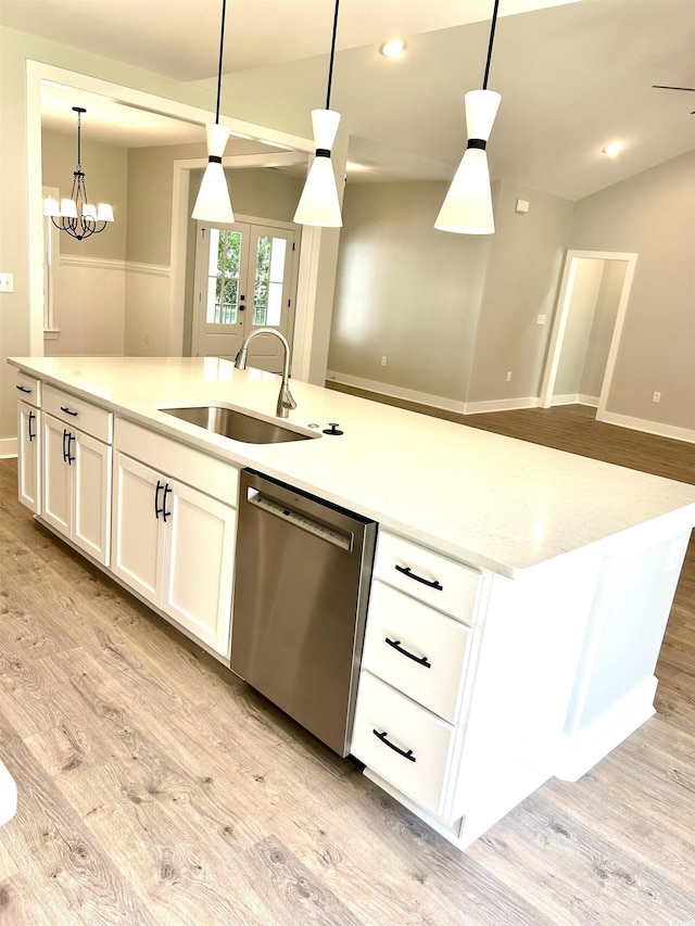 kitchen featuring a sink, light wood finished floors, dishwasher, an island with sink, and white cabinetry
