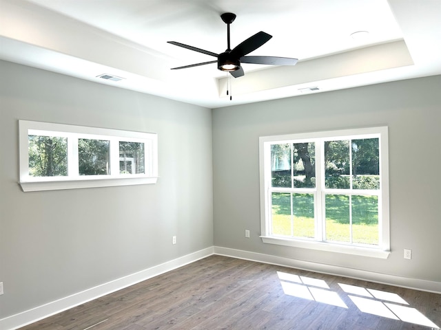 unfurnished room with baseboards, visible vents, and dark wood-type flooring