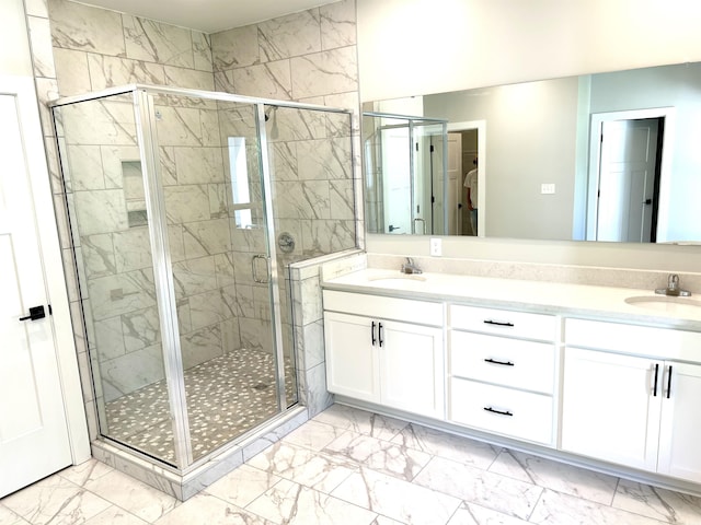 bathroom featuring double vanity, a sink, marble finish floor, and a shower stall