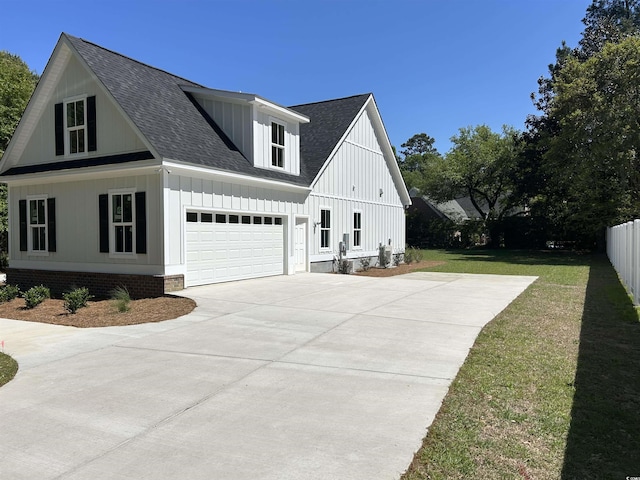 view of side of property with a yard, driveway, board and batten siding, and roof with shingles