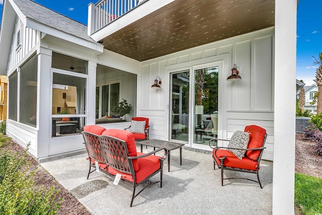 view of patio featuring a balcony and a sunroom