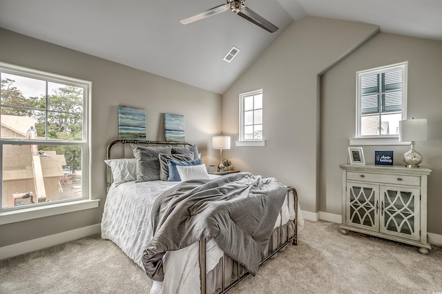 carpeted bedroom with multiple windows, ceiling fan, and vaulted ceiling