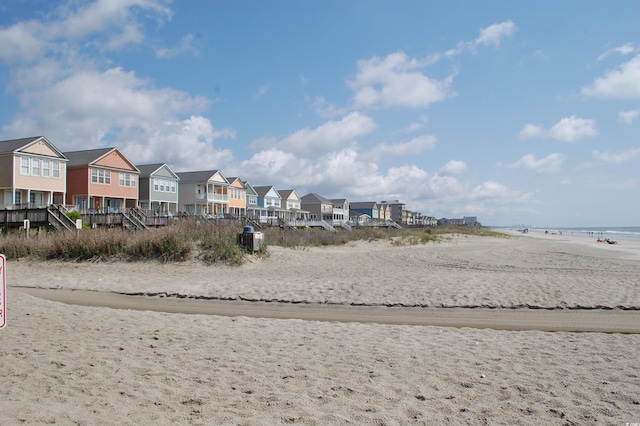 view of community with a water view and a beach view