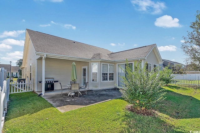 rear view of house featuring a patio area and a lawn