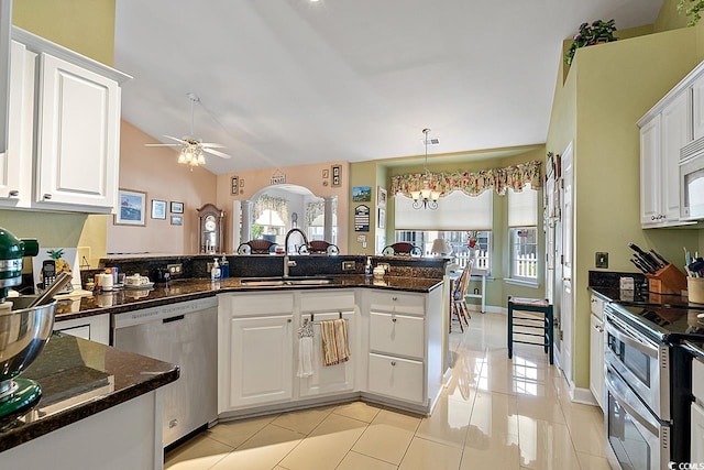 kitchen with kitchen peninsula, appliances with stainless steel finishes, sink, white cabinetry, and lofted ceiling