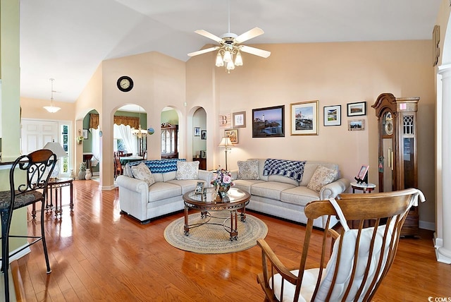 living room with ceiling fan, wood-type flooring, and high vaulted ceiling