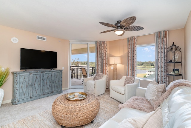 carpeted living room featuring ceiling fan and a healthy amount of sunlight