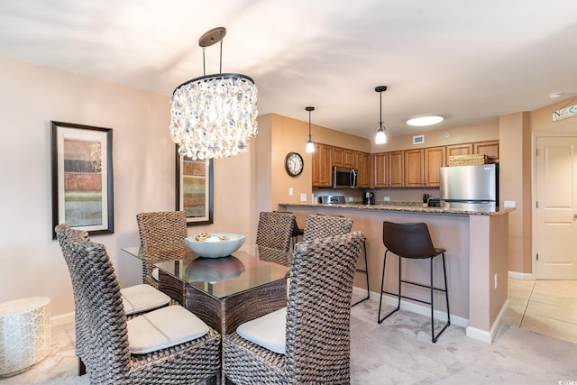 dining space with a notable chandelier and light carpet