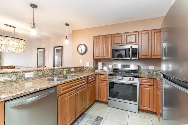 kitchen with stone counters, sink, a notable chandelier, decorative light fixtures, and appliances with stainless steel finishes