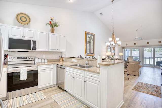 kitchen with kitchen peninsula, stainless steel appliances, white cabinets, and sink