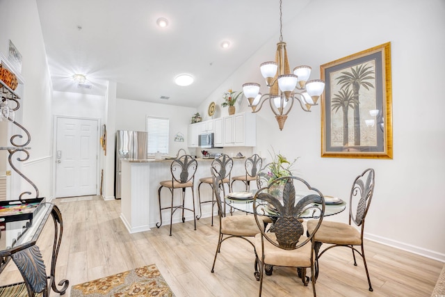 dining room featuring light hardwood / wood-style flooring, lofted ceiling, and an inviting chandelier