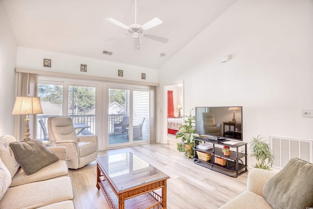 living room with light wood-type flooring, high vaulted ceiling, and ceiling fan