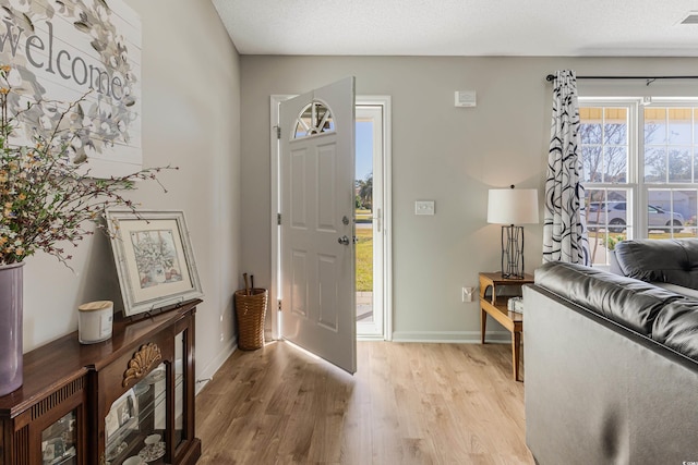 entryway with light hardwood / wood-style floors and a textured ceiling