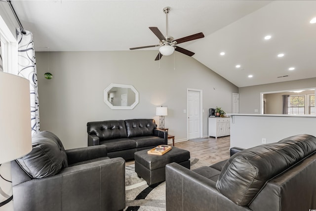 living room with light hardwood / wood-style floors, ceiling fan, and lofted ceiling