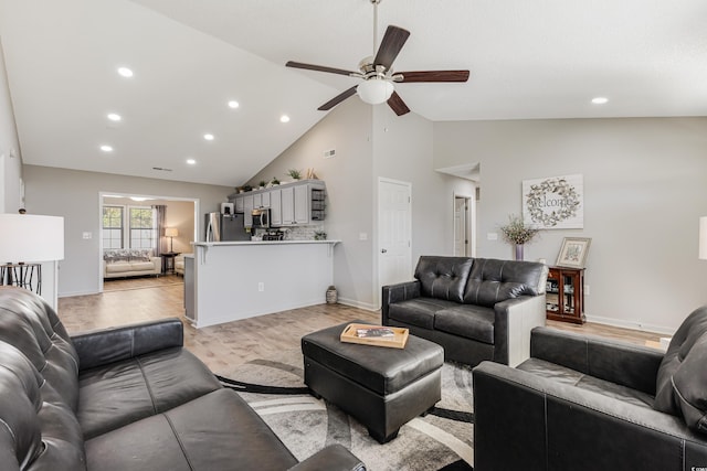 living room featuring ceiling fan, light hardwood / wood-style floors, and high vaulted ceiling