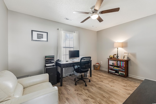 office area featuring ceiling fan, light hardwood / wood-style floors, and a textured ceiling