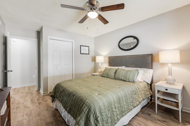 bedroom featuring wood-type flooring, a textured ceiling, a closet, and ceiling fan