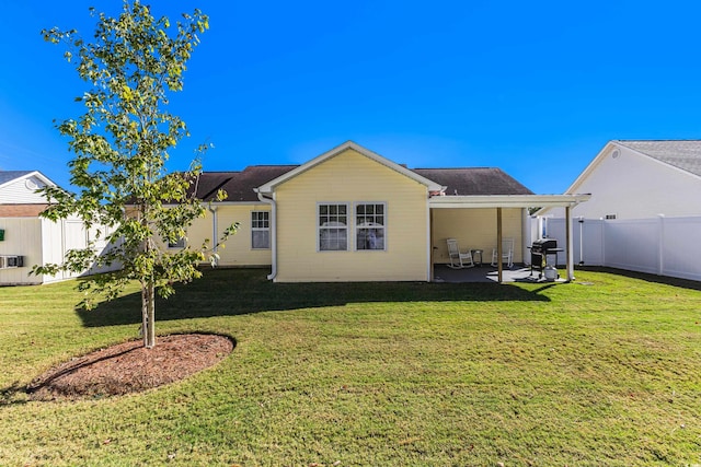 rear view of property featuring a yard and a patio