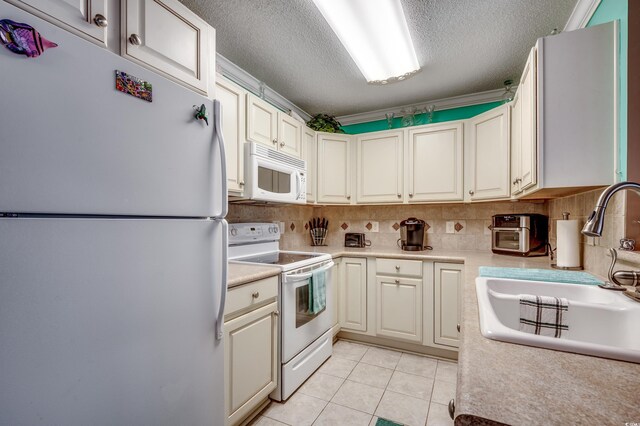 2226 Huntington Dr Unit D, Surfside Beach, SC 29575 - kitchen with white appliances, a sink, a textured ceiling, light countertops, and light tile patterned floors