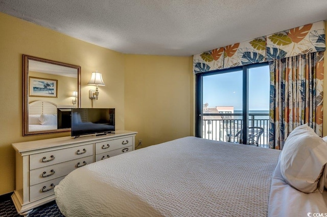 bedroom with access to exterior and a textured ceiling