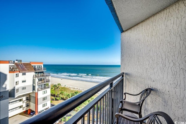 balcony featuring a water view and a beach view