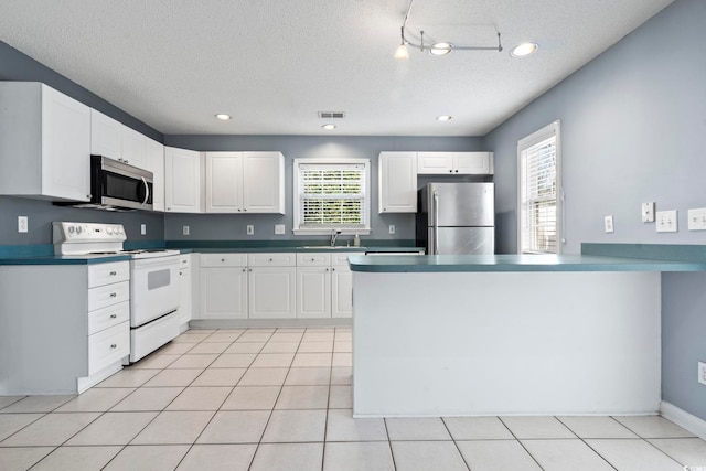 kitchen featuring visible vents, appliances with stainless steel finishes, a sink, and white cabinetry