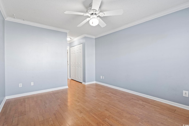 empty room with light wood-type flooring, crown molding, baseboards, and ceiling fan