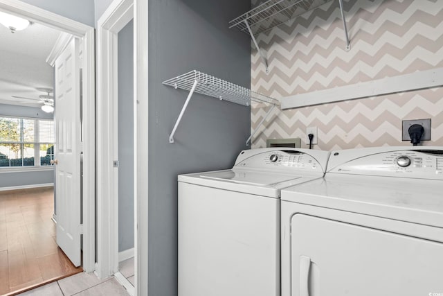 washroom featuring ceiling fan, an accent wall, separate washer and dryer, laundry area, and baseboards