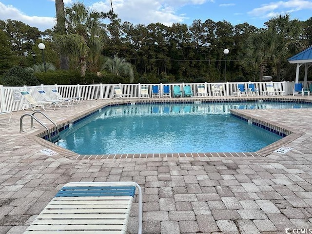 pool with a patio and fence