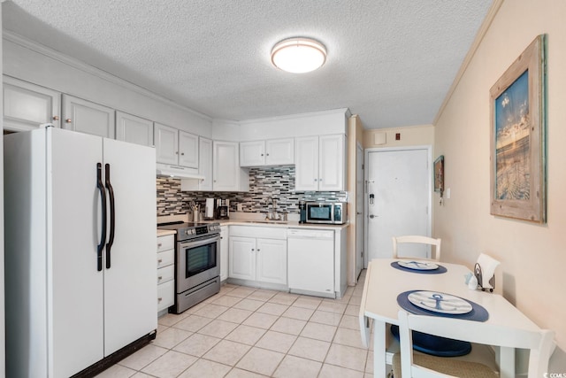 kitchen featuring white cabinets, crown molding, light tile patterned floors, appliances with stainless steel finishes, and tasteful backsplash