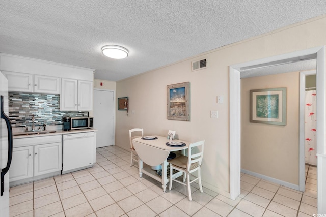 kitchen with decorative backsplash, a textured ceiling, white dishwasher, and white cabinetry