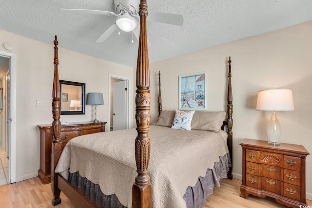 bedroom featuring ceiling fan, light hardwood / wood-style floors, and a textured ceiling