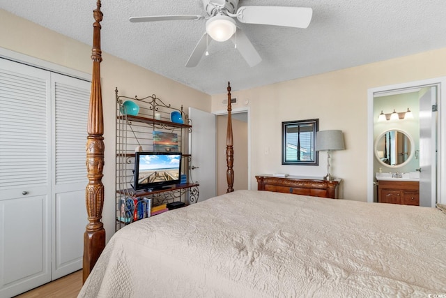 bedroom featuring ensuite bathroom, light hardwood / wood-style flooring, ceiling fan, a textured ceiling, and a closet