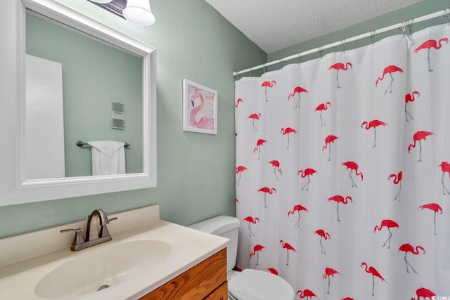 bathroom with a shower with curtain, vanity, toilet, and a textured ceiling