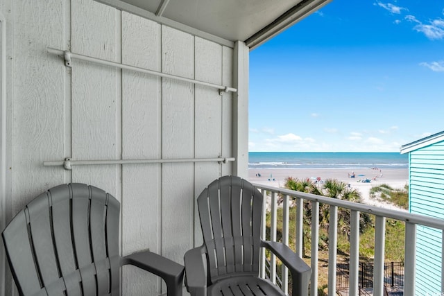 balcony with a water view and a beach view