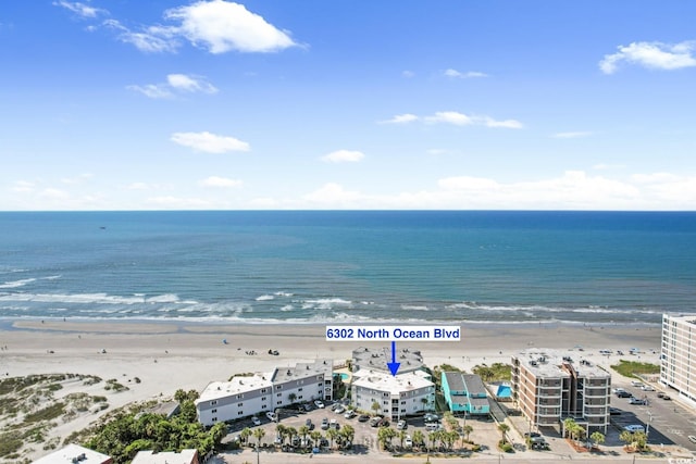 birds eye view of property with a water view and a beach view