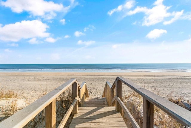 view of property's community featuring a water view and a beach view