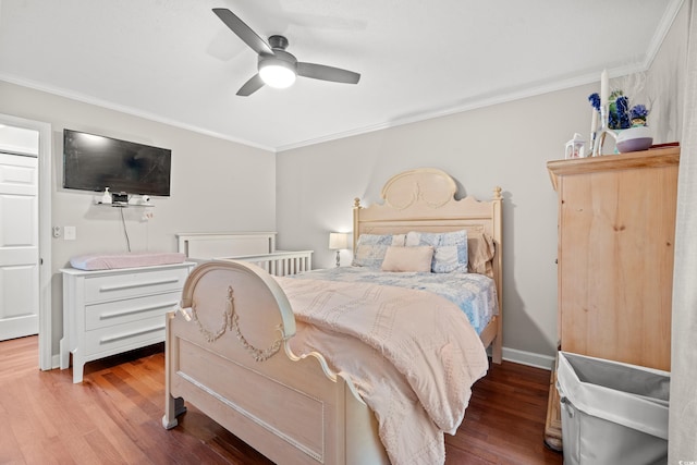 bedroom with crown molding, a ceiling fan, and wood finished floors