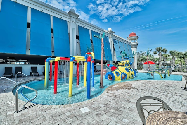 view of community featuring a playground, a patio area, and a pool