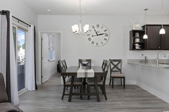 dining room featuring sink, a notable chandelier, and hardwood / wood-style flooring